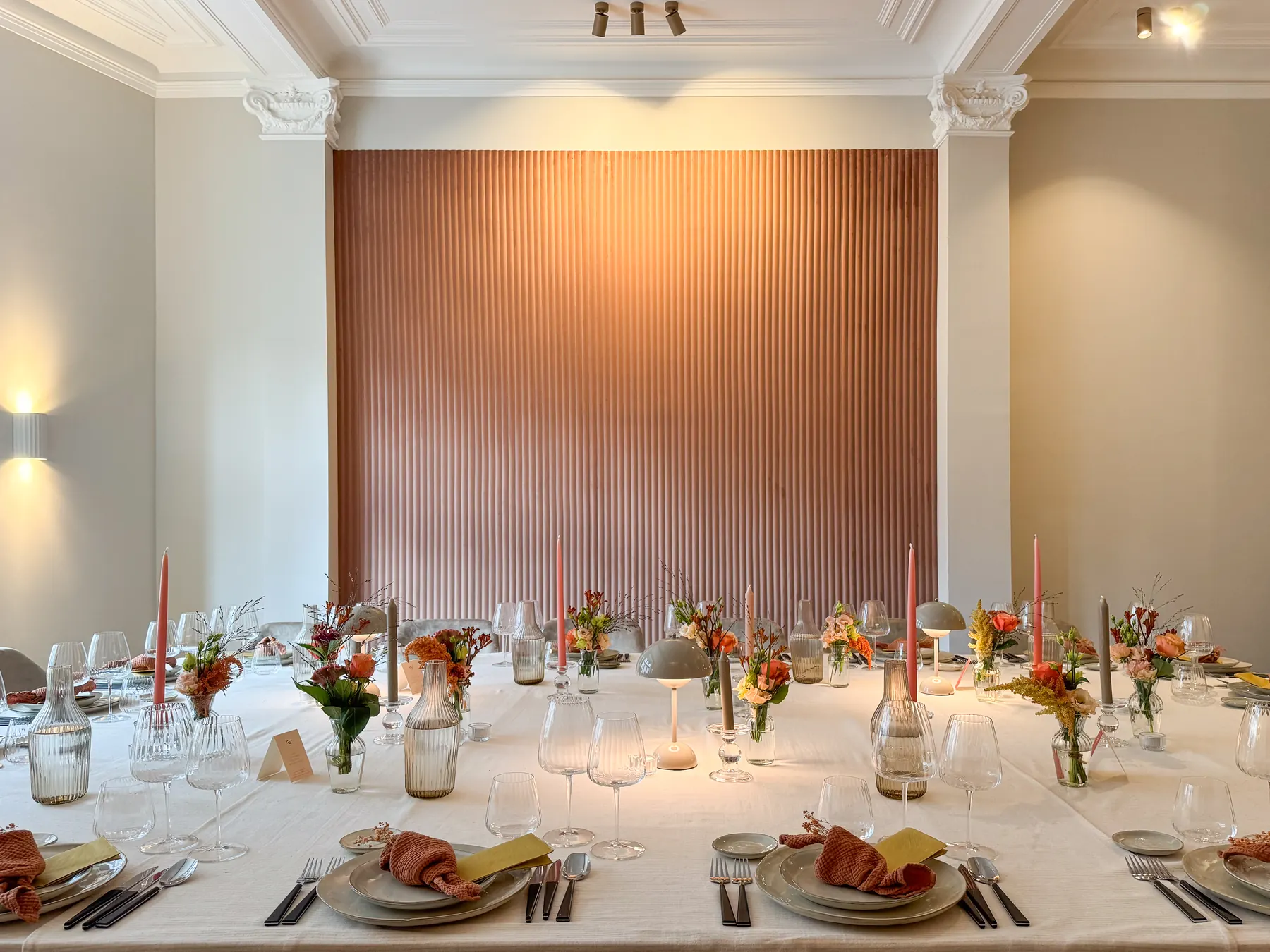 A candlelit table laid with crystal glasses and pale roses